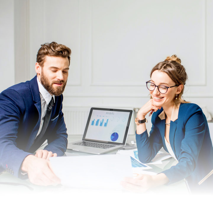 young man and woman sitting at conference table with laptop