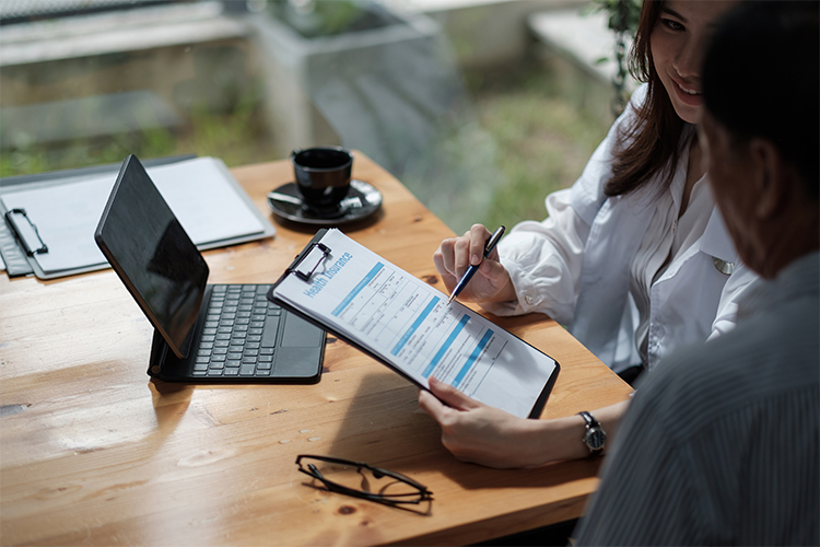 Female health insurance broker presenting insurance benefits to businessman